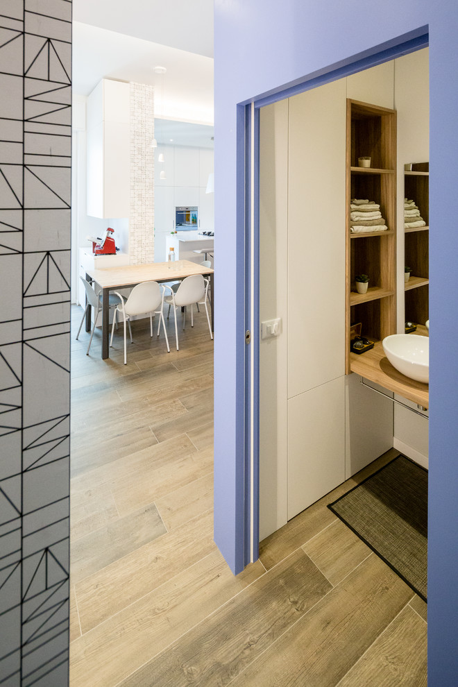 Kleine Moderne Gästetoilette mit offenen Schränken, Wandtoilette mit Spülkasten, Zementfliesen, grauer Wandfarbe, Porzellan-Bodenfliesen, Aufsatzwaschbecken und braunem Boden in Mailand