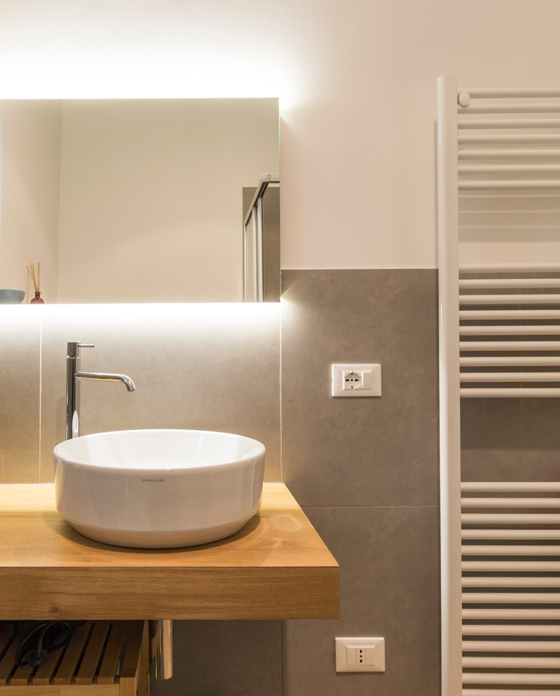 Ispirazione per un bagno di servizio design di medie dimensioni con WC a due pezzi, piastrelle grigie, piastrelle di cemento, pareti bianche, parquet chiaro, lavabo a bacinella, top in legno, pavimento giallo e top giallo