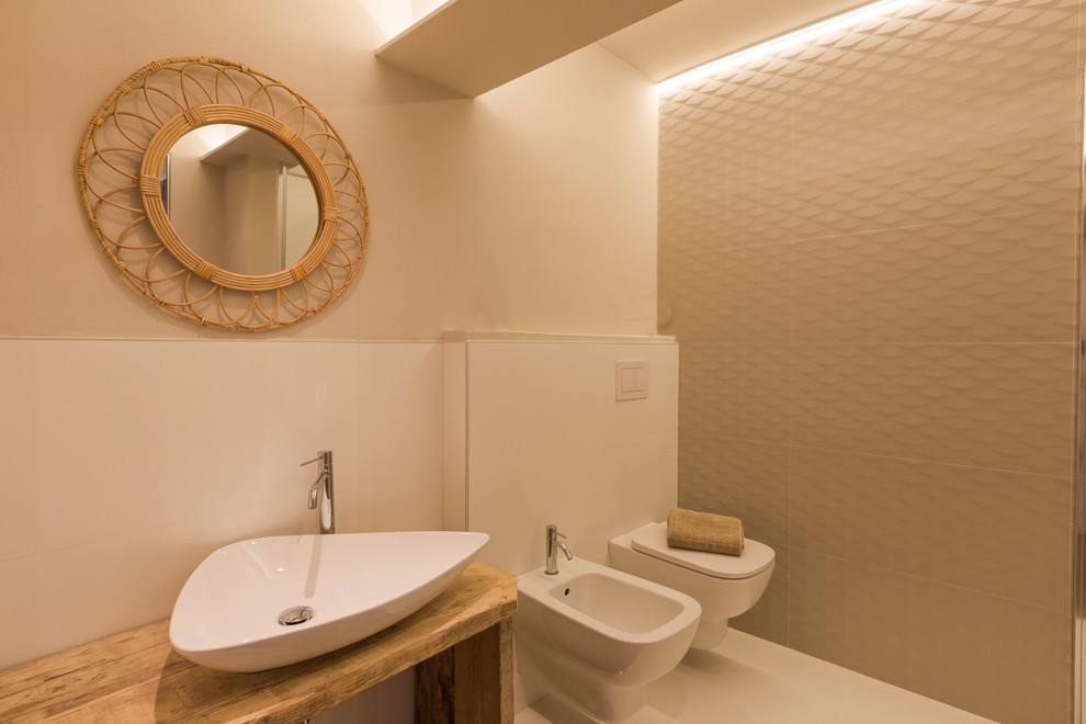 Foto di un bagno di servizio tropicale di medie dimensioni con ante beige, WC sospeso, piastrelle bianche, pareti beige, lavabo a bacinella, top in legno, pavimento bianco e top beige