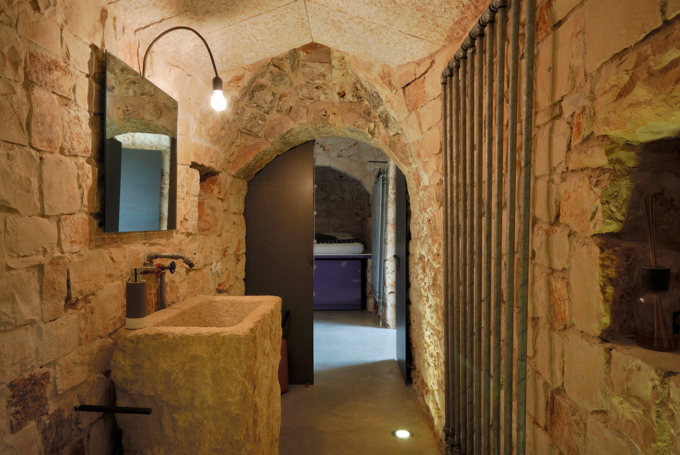 Пример оригинального дизайна: туалет в средиземноморском стиле с бетонным полом, бежевыми стенами, раковиной с пьедесталом и серым полом