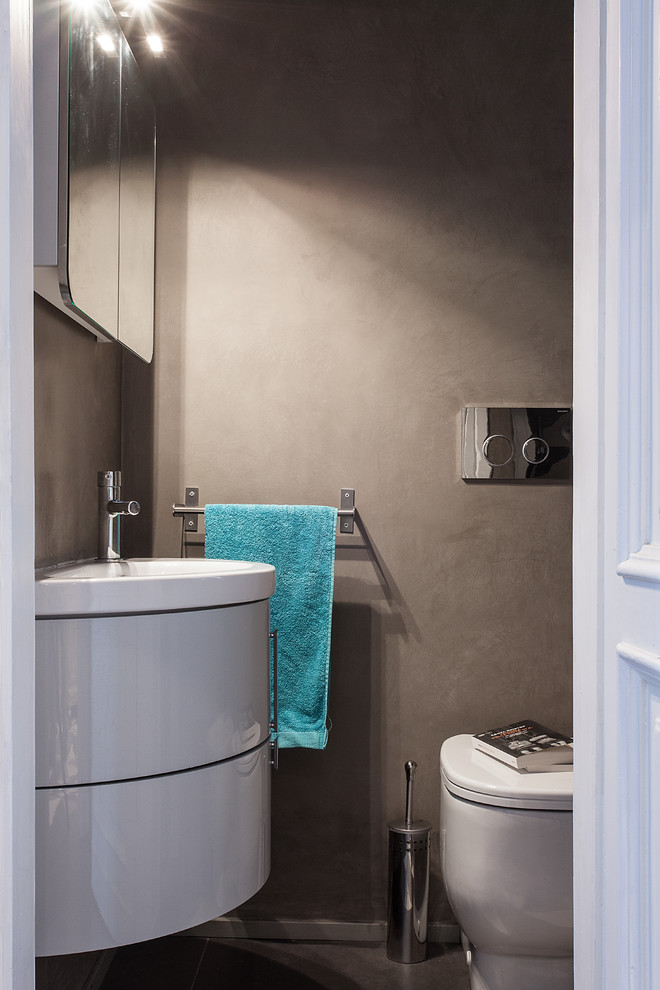Источник вдохновения для домашнего уюта: маленький туалет в современном стиле с плоскими фасадами, серыми фасадами, раздельным унитазом, серой плиткой, серыми стенами, полом из керамической плитки, монолитной раковиной и разноцветным полом для на участке и в саду