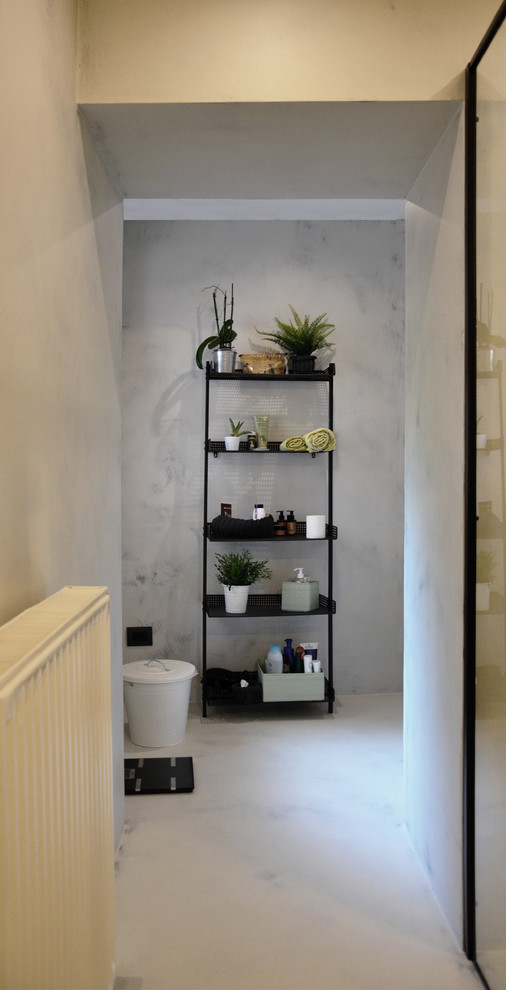 This is an example of a small urban cloakroom in Other with open cabinets, black cabinets, a wall mounted toilet, grey tiles, grey walls, concrete flooring, a vessel sink, concrete worktops, grey floors and grey worktops.