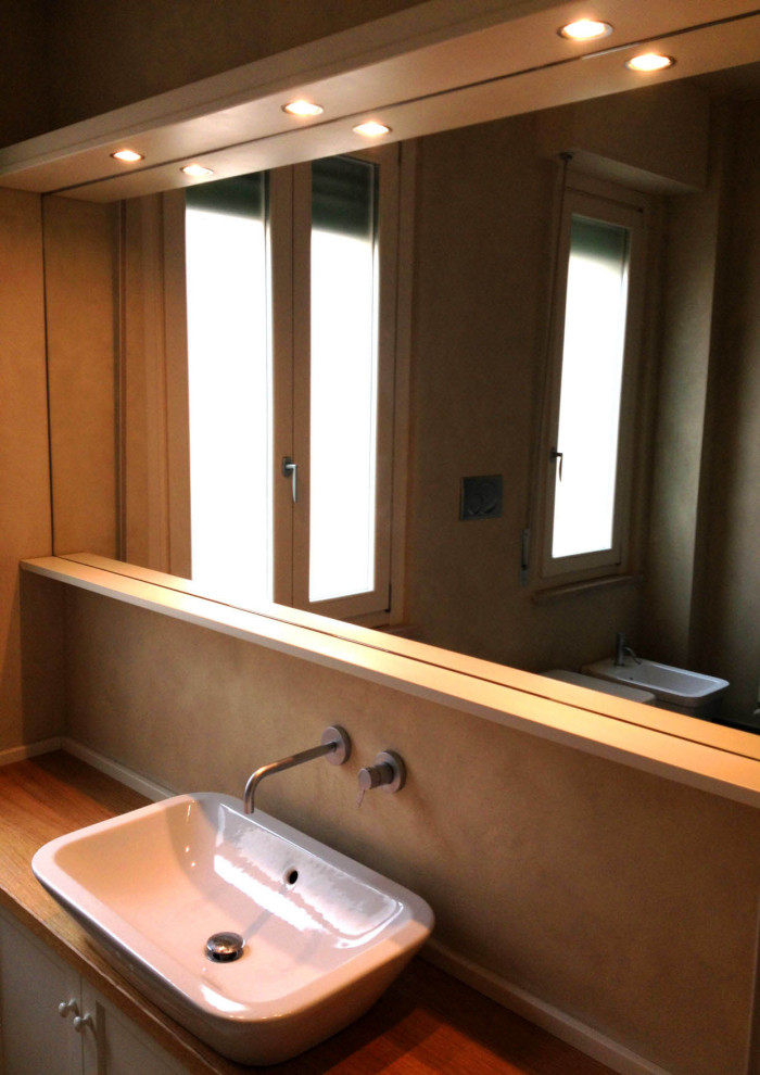 Mittelgroße Moderne Gästetoilette mit Schrankfronten mit vertiefter Füllung, weißen Schränken, beiger Wandfarbe, Schieferboden, Aufsatzwaschbecken, Waschtisch aus Holz, grünem Boden und brauner Waschtischplatte in Sonstige