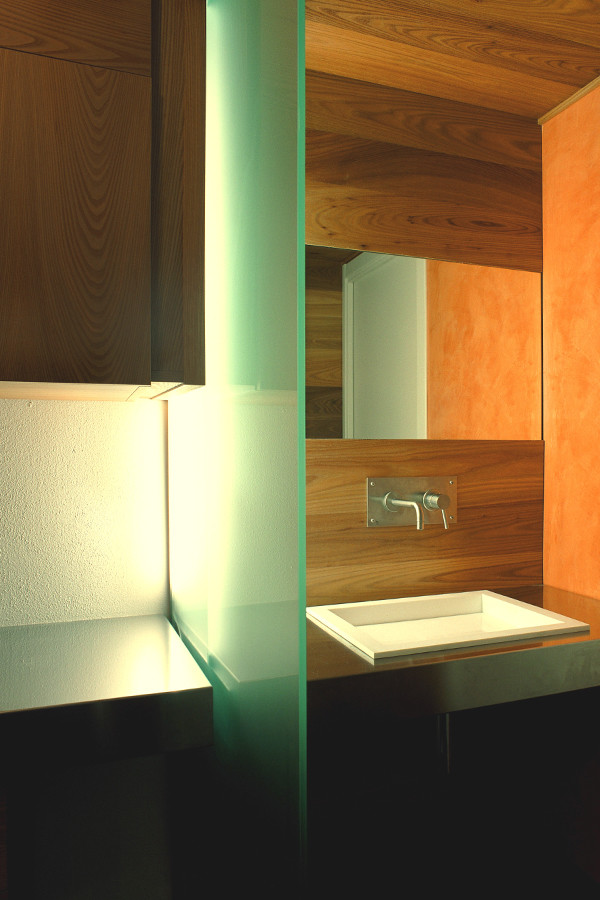 Cette image montre un petit WC et toilettes chalet en bois brun avec un placard à porte plane, un mur multicolore, un sol en carrelage de céramique, un lavabo posé, un plan de toilette en acier inoxydable et un carrelage multicolore.