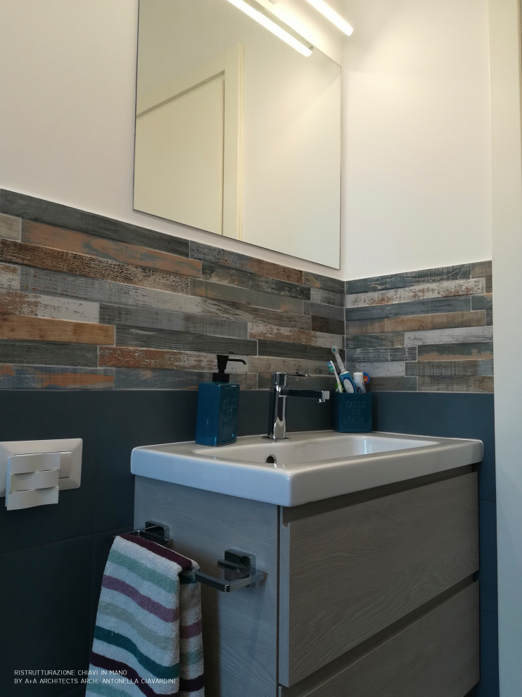 Photo of a small contemporary cloakroom in Other with flat-panel cabinets, light wood cabinets, a wall mounted toilet, multi-coloured tiles, porcelain tiles, white walls, porcelain flooring, a wall-mounted sink, solid surface worktops, brown floors and white worktops.