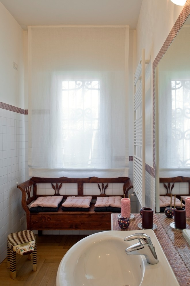 На фото: туалет среднего размера в современном стиле с раздельным унитазом, красными стенами, светлым паркетным полом, монолитной раковиной и столешницей из плитки с