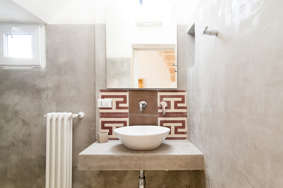 На фото: туалет в средиземноморском стиле с столешницей из бетона с
