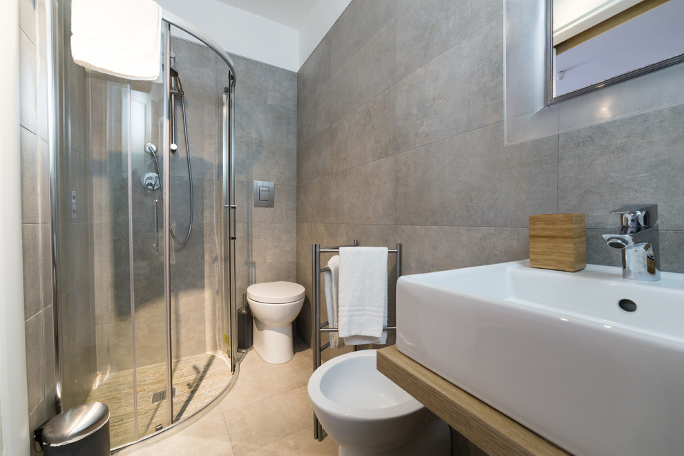 Immagine di una stanza da bagno minimalista con piastrelle grigie, pareti grigie, pavimento con piastrelle in ceramica, lavabo a bacinella, top in legno e pavimento beige