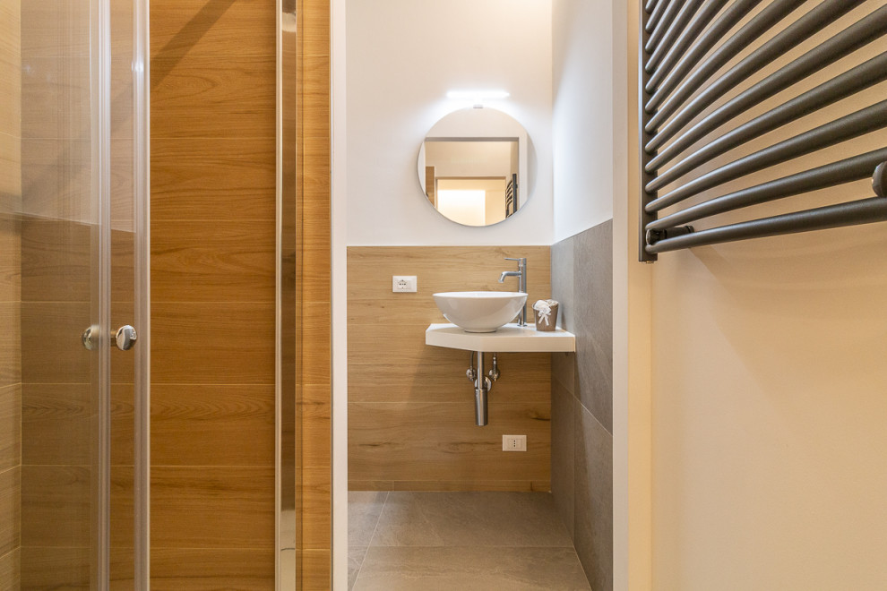 Immagine di un piccolo bagno di servizio design con WC monopezzo, pavimento in gres porcellanato, lavabo a bacinella e pavimento grigio