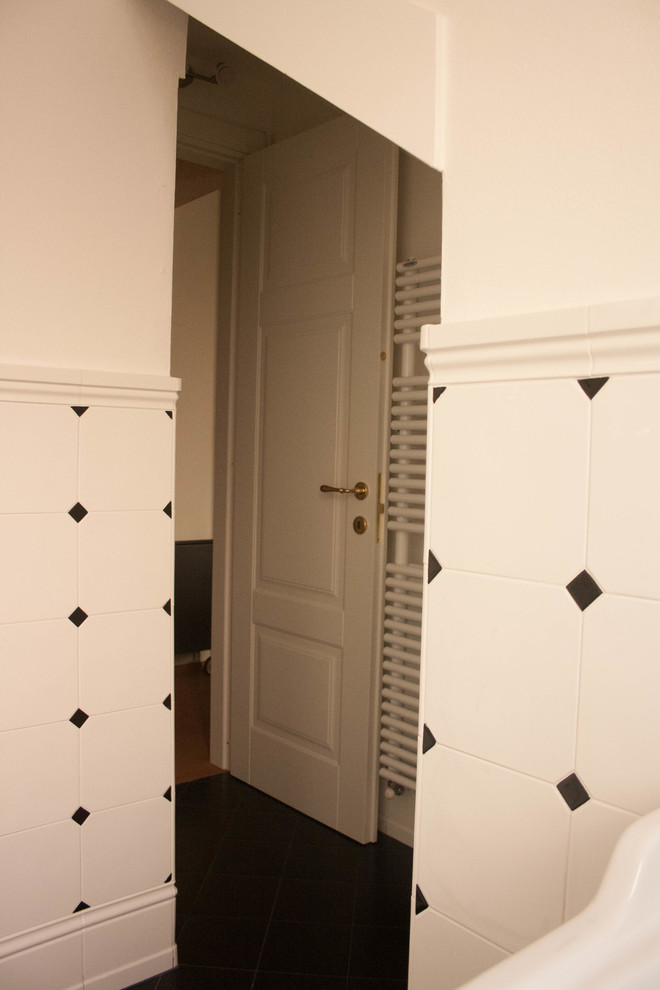 Exempel på ett litet klassiskt toalett, med en toalettstol med separat cisternkåpa, svart och vit kakel, keramikplattor, vita väggar, klinkergolv i keramik och svart golv