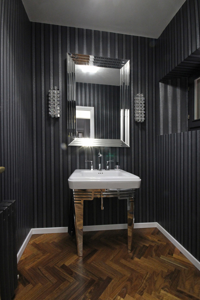 Foto di un bagno di servizio tradizionale di medie dimensioni con WC monopezzo, piastrelle nere, pareti nere, pavimento in legno verniciato, lavabo a consolle e pavimento marrone