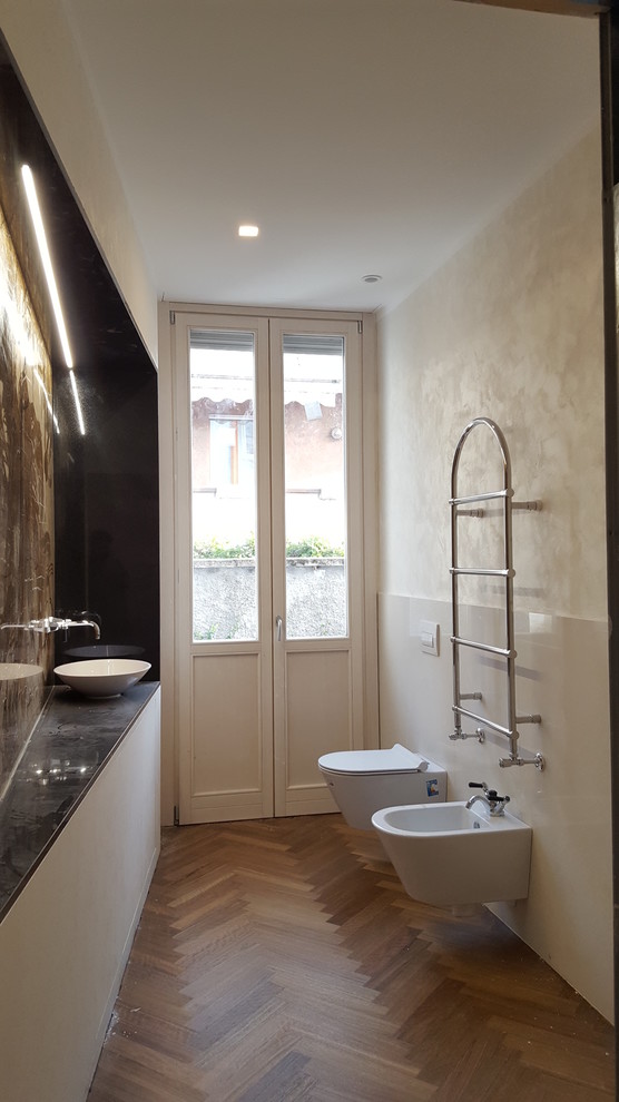 This is an example of a classic cloakroom in Milan with medium hardwood flooring, a vessel sink and marble worktops.