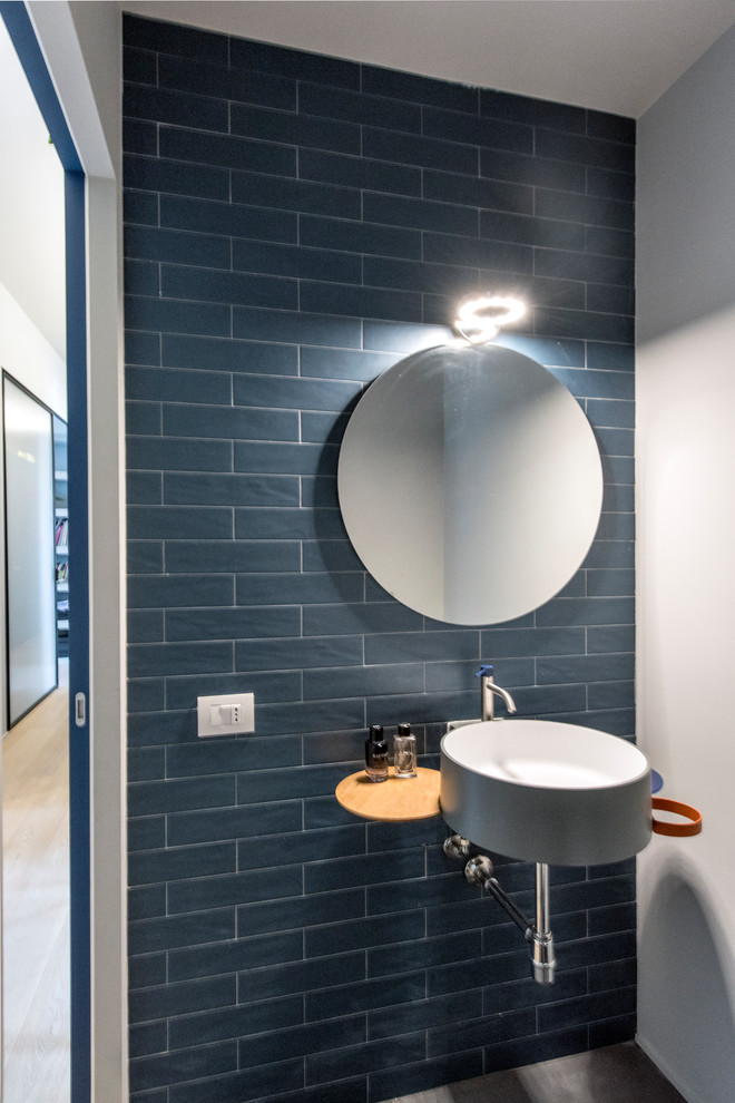 Foto di un piccolo bagno di servizio minimal con WC sospeso, piastrelle blu, piastrelle in gres porcellanato, pareti blu, pavimento in gres porcellanato, lavabo sospeso e pavimento grigio