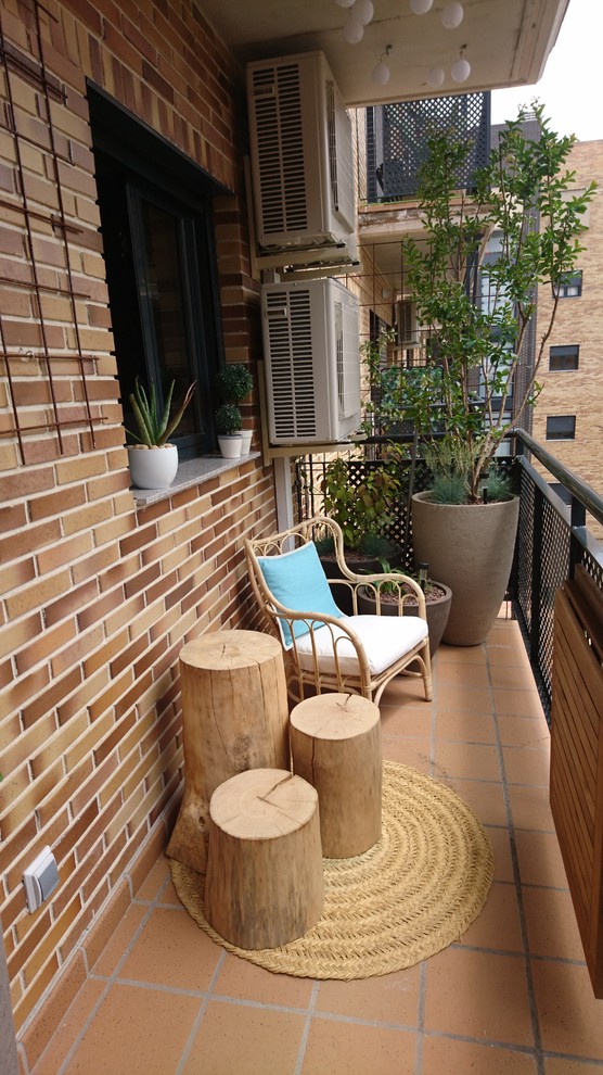 Ispirazione per un piccolo balcone con un giardino in vaso, un parasole e parapetto in metallo