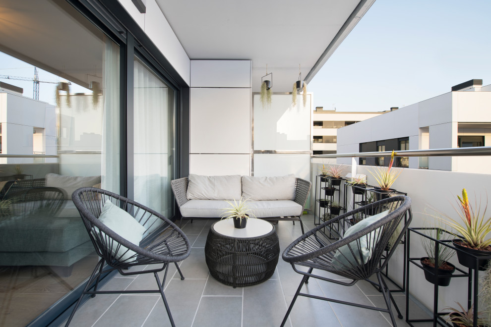 Foto på en mellanstor minimalistisk balkong, med takförlängning och räcke i flera material