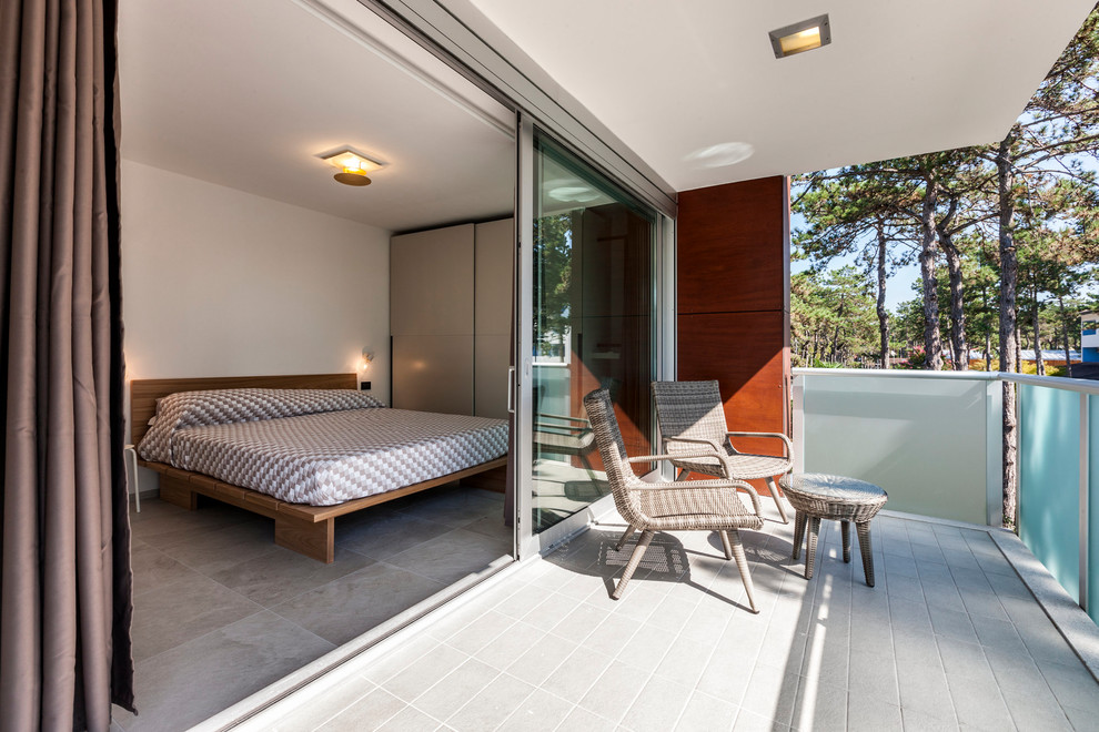 Cette image montre un balcon minimaliste avec une extension de toiture et un garde-corps en verre.