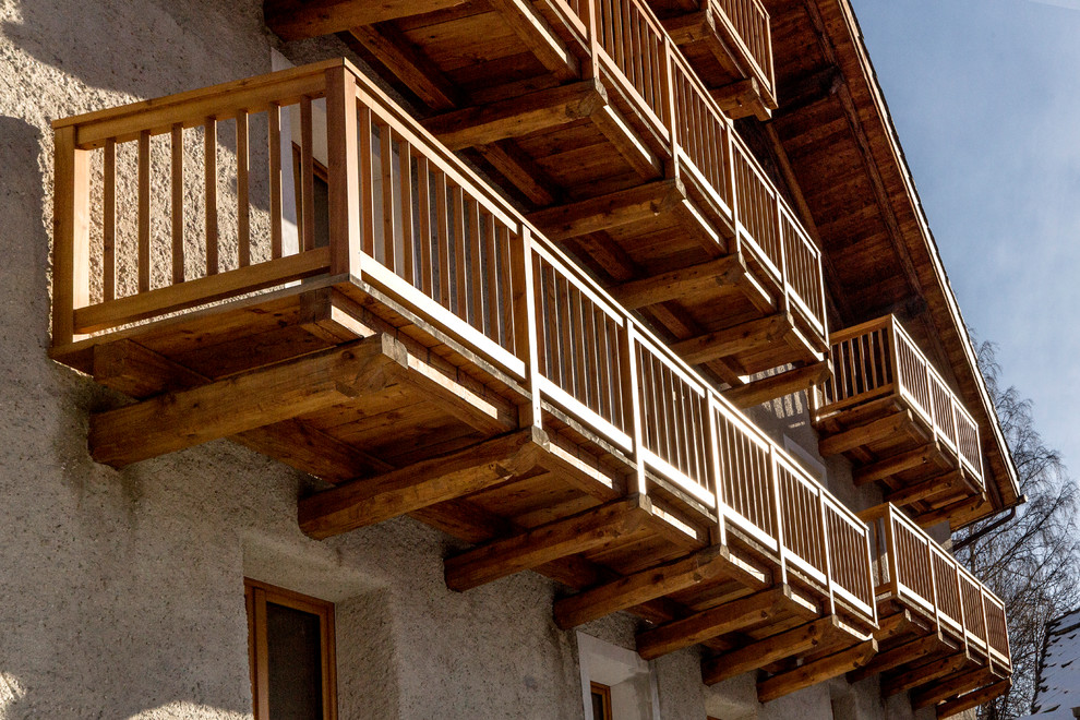 Idée de décoration pour un grand balcon chalet avec un garde-corps en bois.