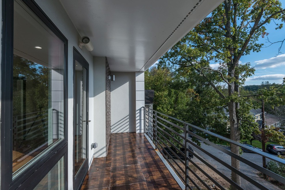 Exemple d'un grand balcon tendance avec une extension de toiture.