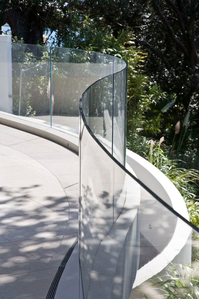 Idée de décoration pour un balcon minimaliste de taille moyenne avec un jardin vertical, une extension de toiture et un garde-corps en verre.