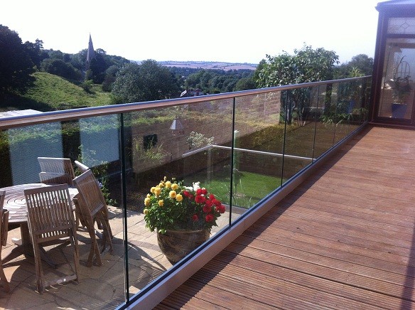 Réalisation d'un balcon minimaliste de taille moyenne avec un jardin vertical, une extension de toiture et un garde-corps en verre.