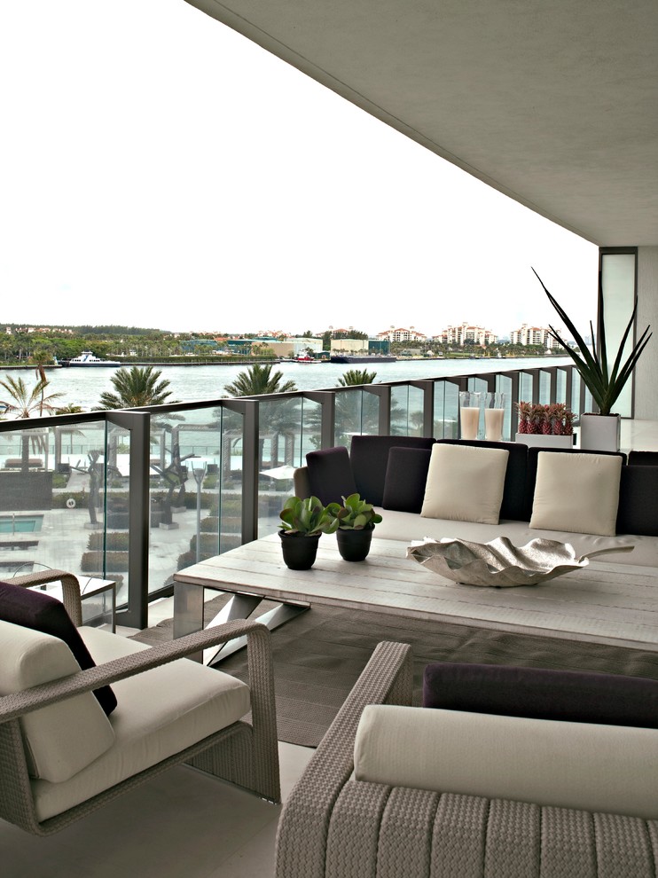 Design ideas for a contemporary balcony in Miami with a roof extension.
