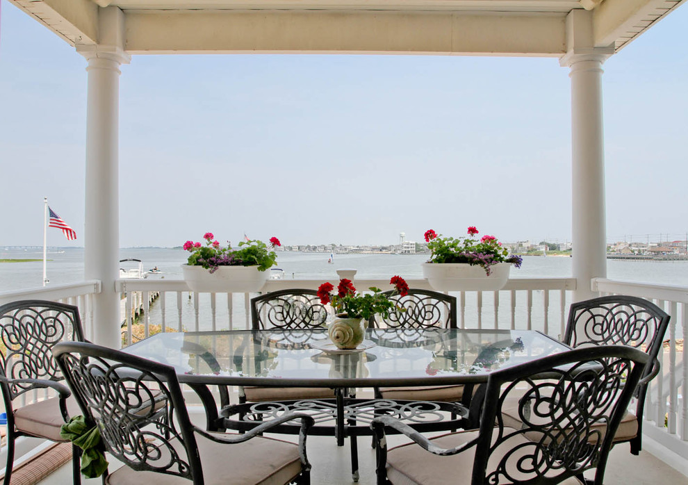 Example of a beach style balcony design in Philadelphia with a roof extension