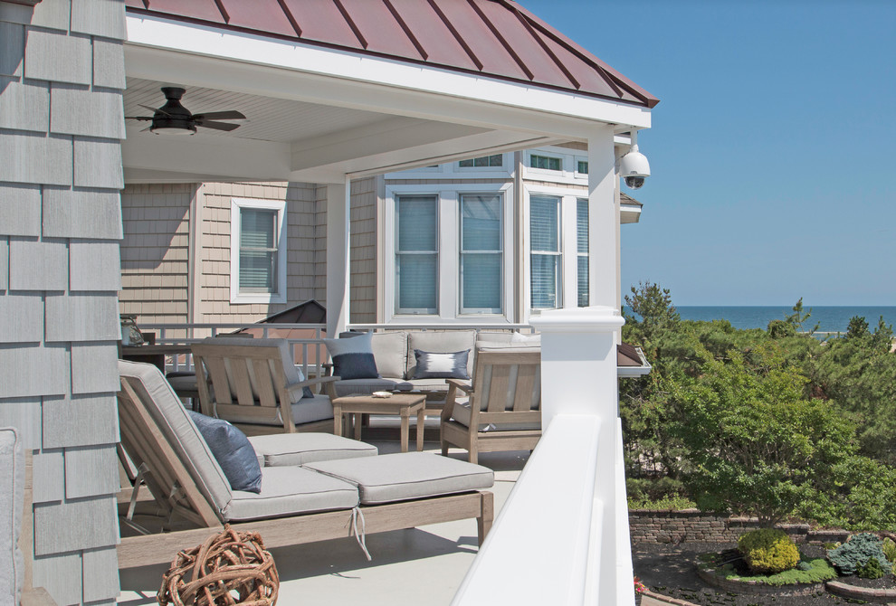 Inspiration for a large coastal balcony remodel in New York with a roof extension