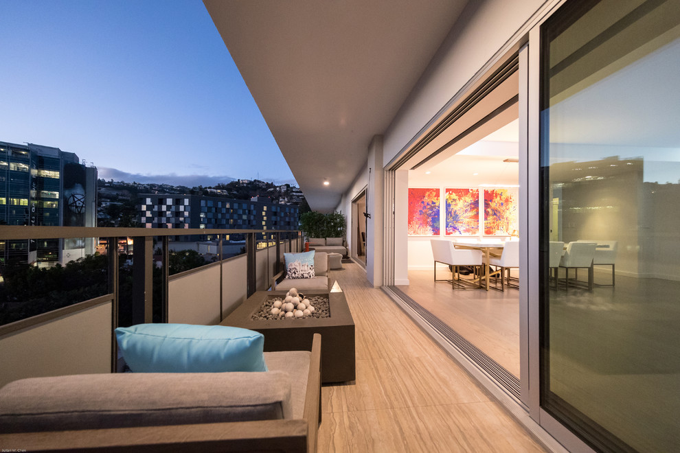 Réalisation d'un balcon design de taille moyenne avec un foyer extérieur et une extension de toiture.