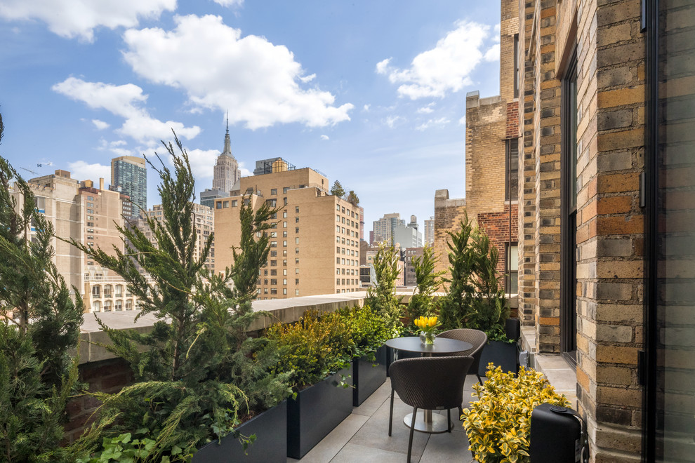 This is an example of a small contemporary apartment balcony in New York with no cover.