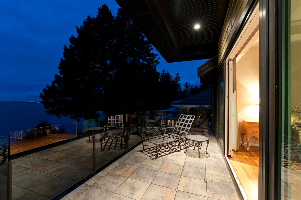 Medium sized contemporary balcony in Vancouver with a roof extension.