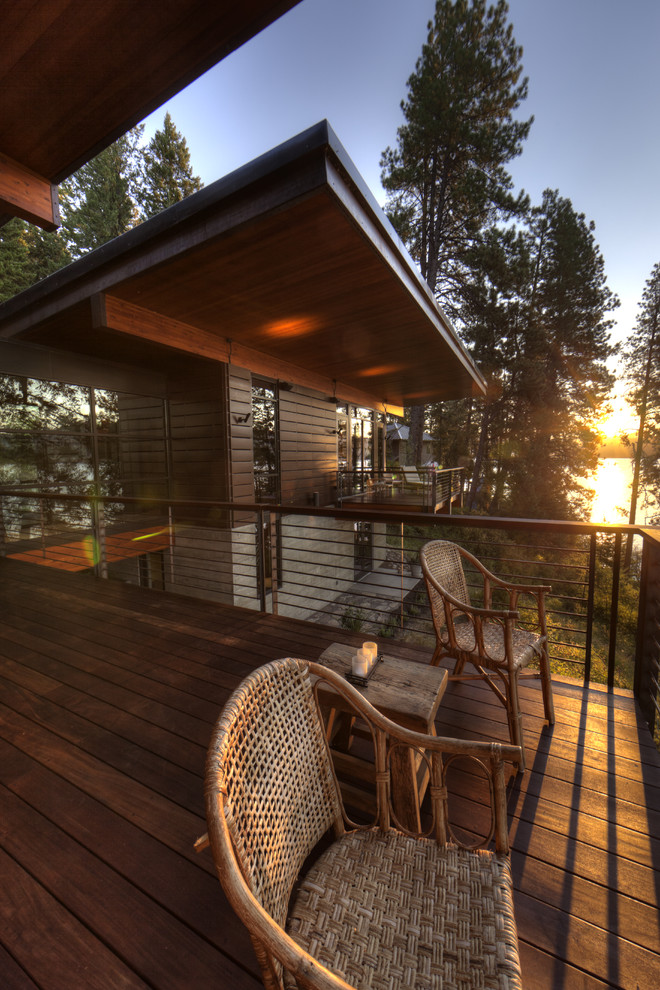 This is an example of a large rustic balcony in Seattle with a roof extension.