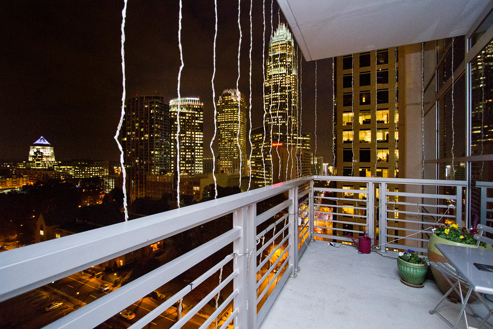 Réalisation d'un petit balcon tradition d'appartement avec une extension de toiture et un garde-corps en métal.