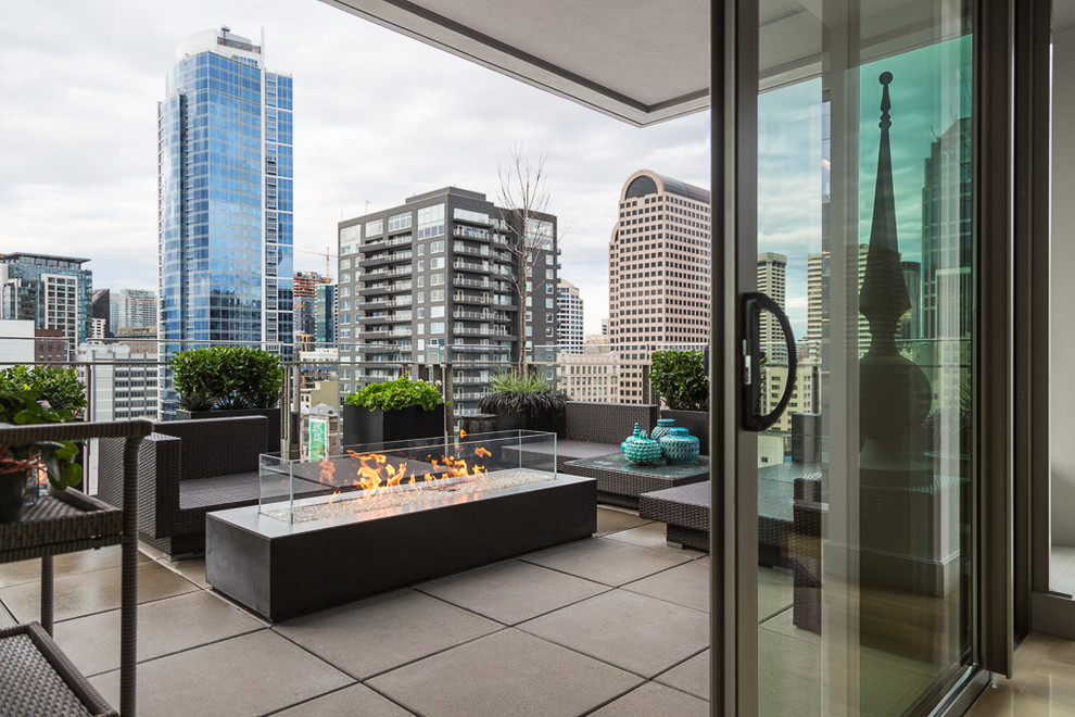 Large trendy balcony photo in Seattle with a fire pit and a roof extension