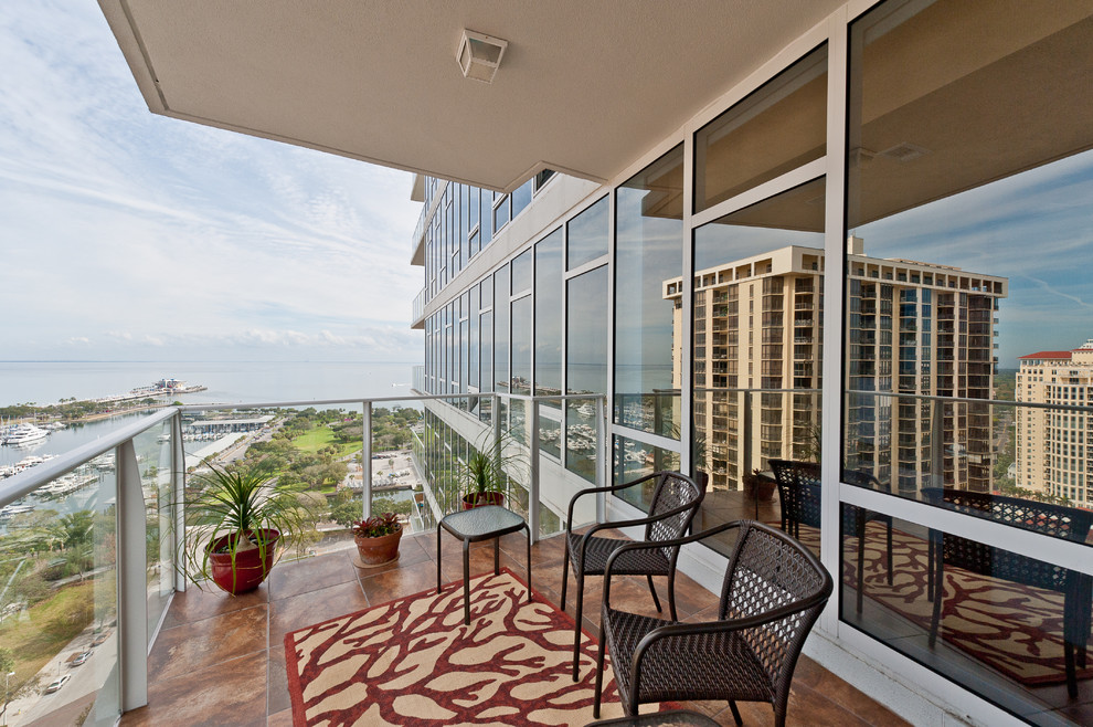 This is an example of a contemporary balcony in Tampa with a roof extension.