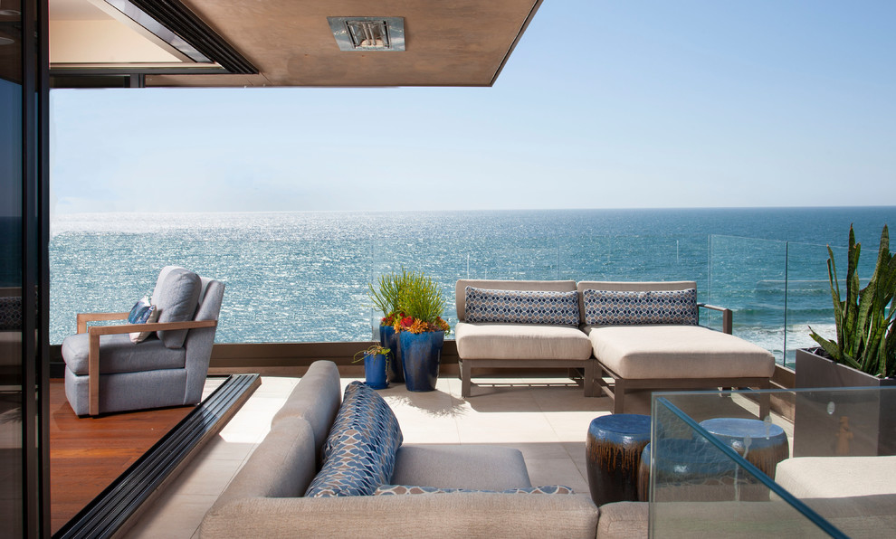 Réalisation d'un balcon marin avec des plantes en pot, une extension de toiture et un garde-corps en verre.