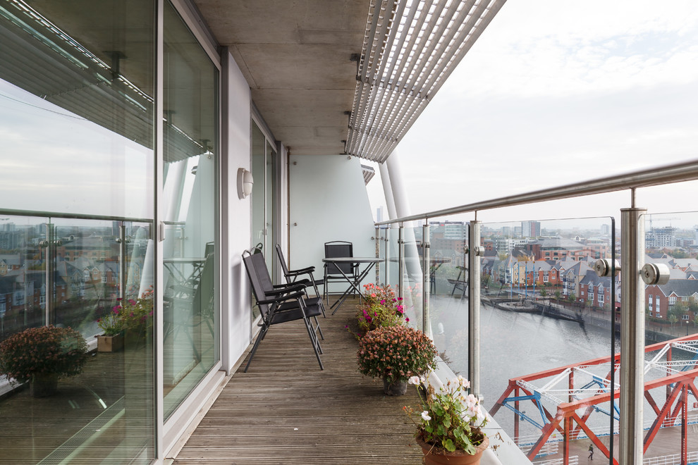 This is an example of a contemporary mixed railing balcony in Manchester with an awning.