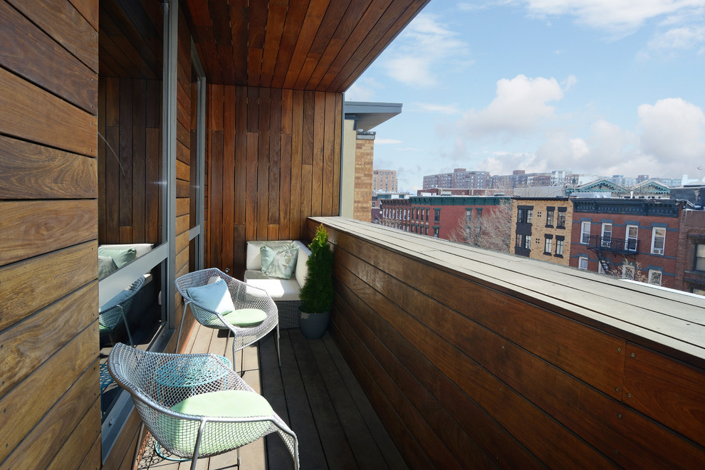 Inspiration for a small contemporary balcony in New York with a roof extension.