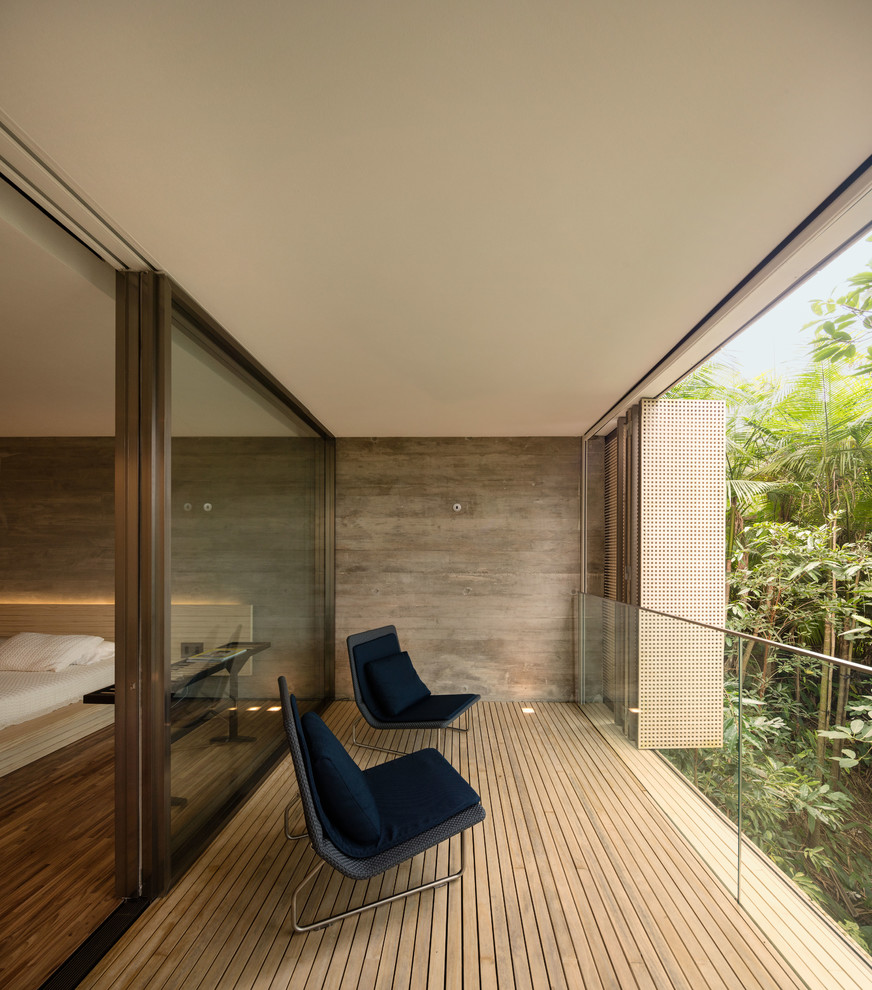 Example of a huge minimalist privacy balcony design in Other with a roof extension