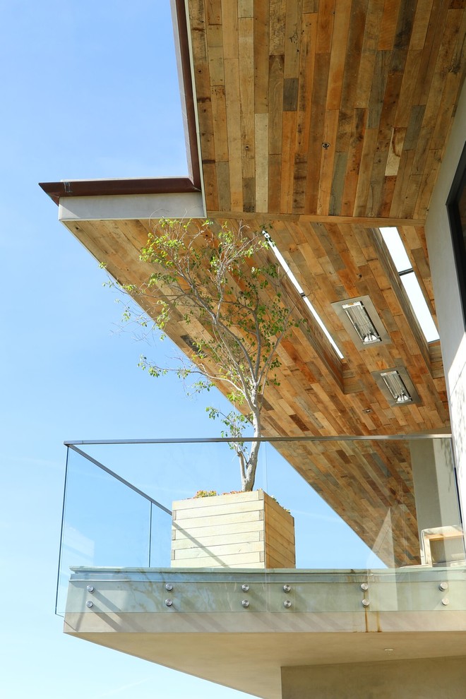 Exempel på en stor modern balkong, med räcke i glas