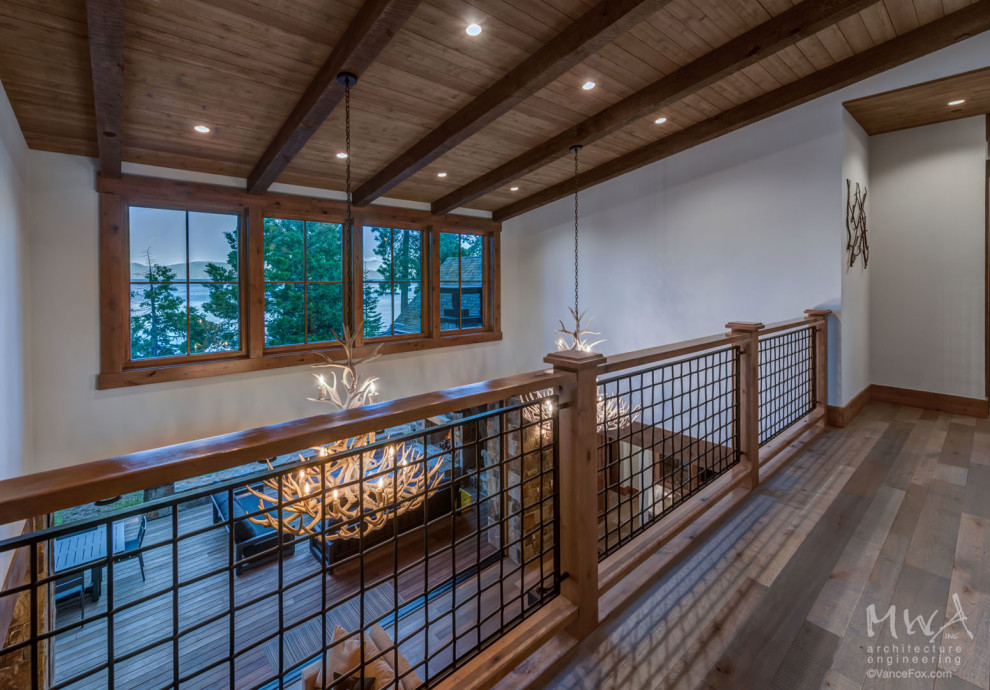 This is an example of a large classic wood railing balcony in Other with a roof extension.