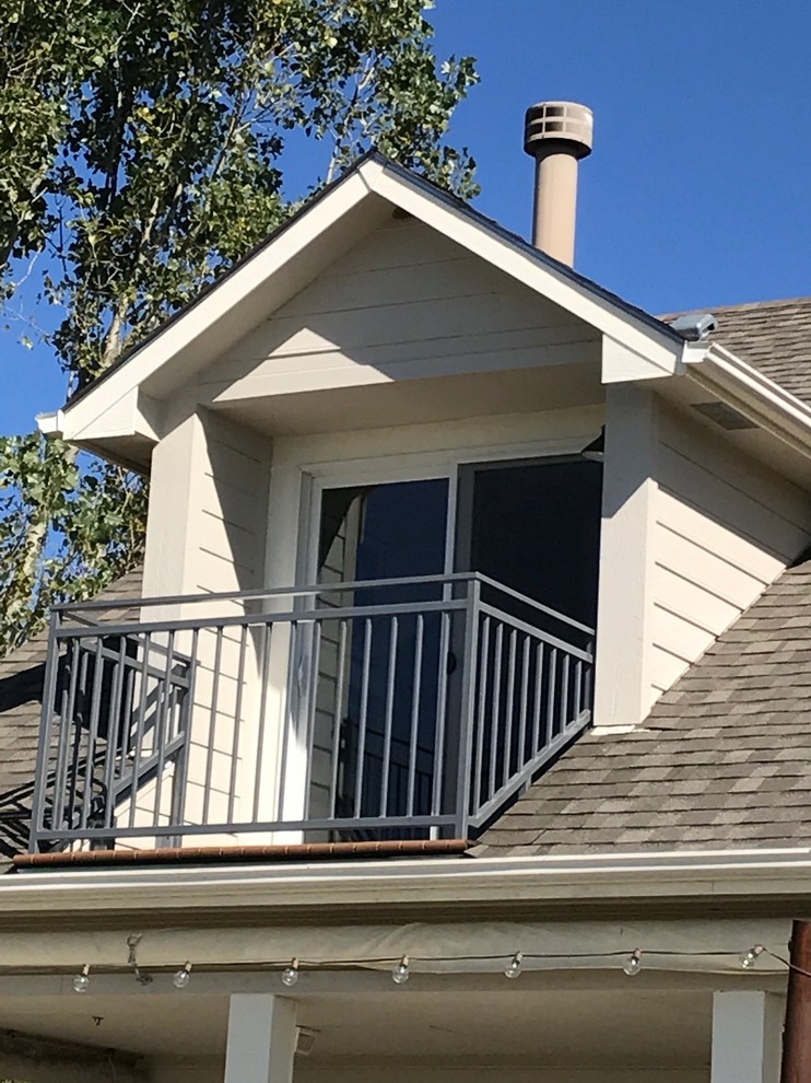 Small classic metal railing balcony in Denver with a roof extension.