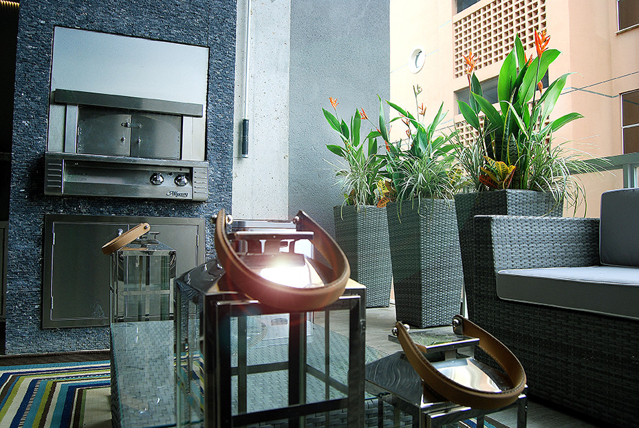 Bild på en mellanstor funkis balkong, med utekrukor och räcke i glas