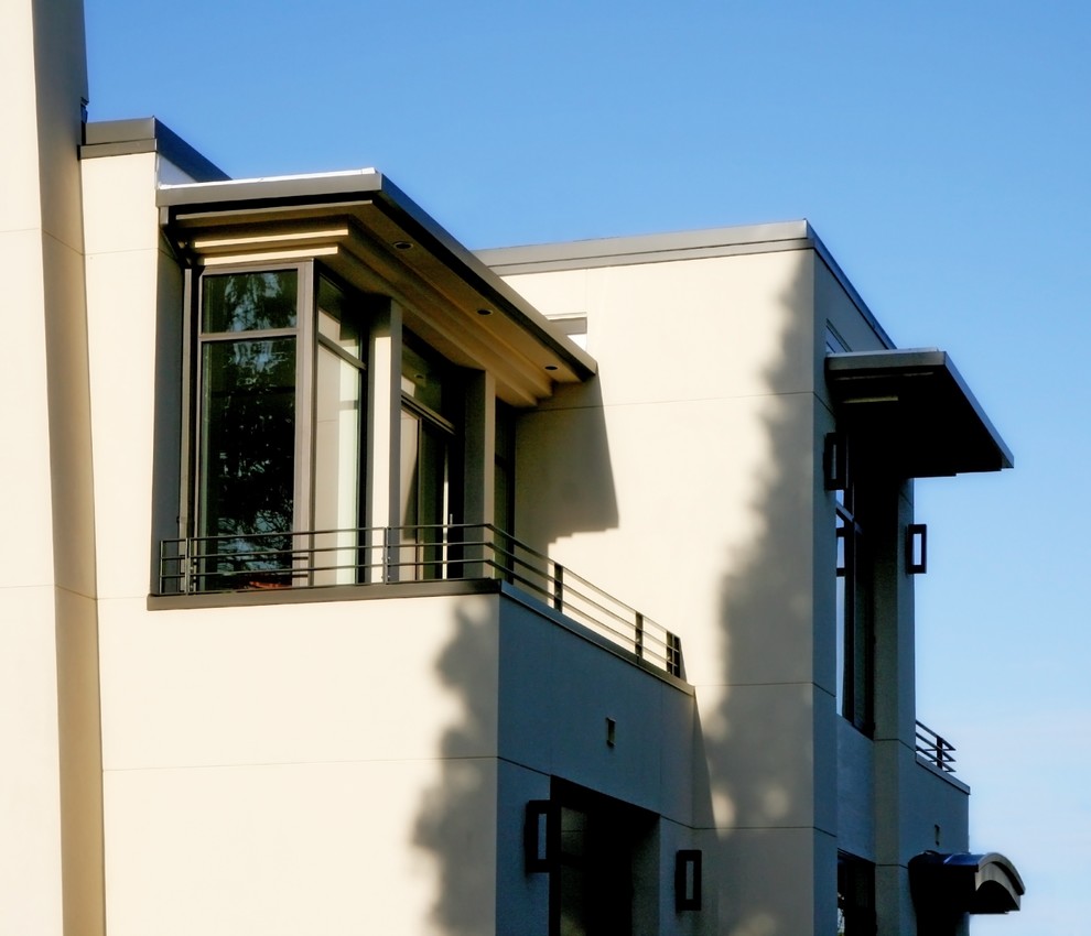 Cette photo montre un balcon moderne avec une extension de toiture et un garde-corps en métal.
