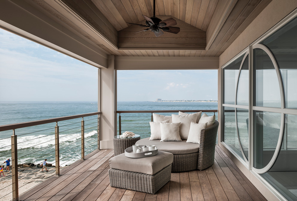 Exemple d'un balcon bord de mer avec une extension de toiture.