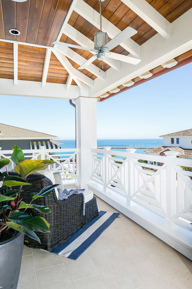 Large island style wood railing balcony photo in Orange County with a roof extension