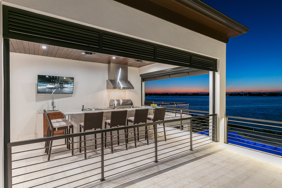 Photo of a beach style terrace in Tampa with a roof extension and a bar area.
