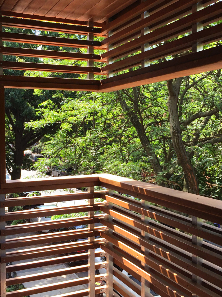 Kleiner, Überdachter Moderner Balkon mit Sichtschutz und Holzgeländer in New York
