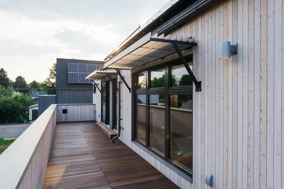 Cette image montre un petit balcon minimaliste avec un auvent et un garde-corps en bois.