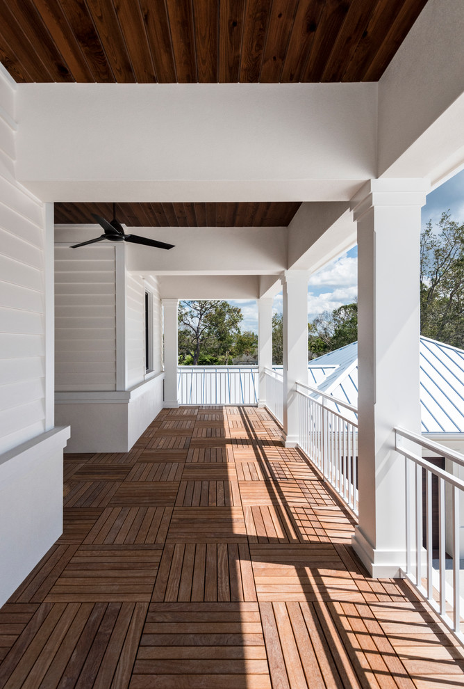 Example of a large transitional metal railing balcony design in Miami with a roof extension