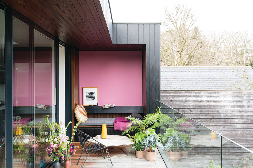 Foto di un balcone minimal con un giardino in vaso, un tetto a sbalzo e parapetto in vetro